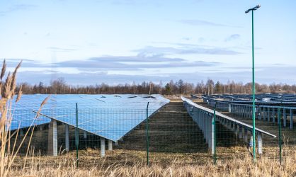 View of the solar power plant on a green field. Electric farm with panels for producing clean ecologic energy.
